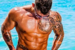 בחור מקועקע עם גוף שרירי בבריכה
