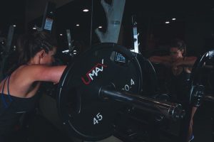 אישה מרימה משקולות בחדר כושר