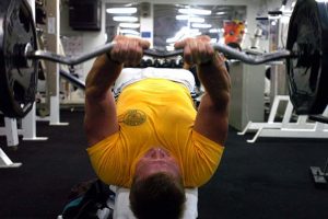 אדם בחדר הכושר מרים משקולות